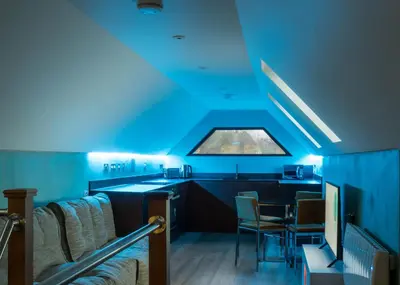 a blue room with chairs and a table at Chy Glynn. Luxury lodge with hot tub and views. in St. Agnes