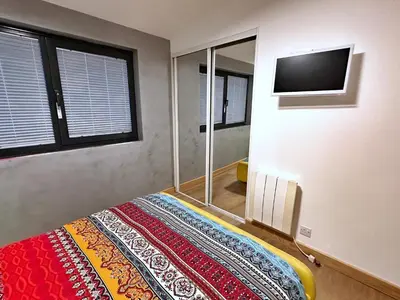 a bedroom with a bed and a flat screen tv at Chy Mena. South facing lodge with hot tub & views. in St. Agnes