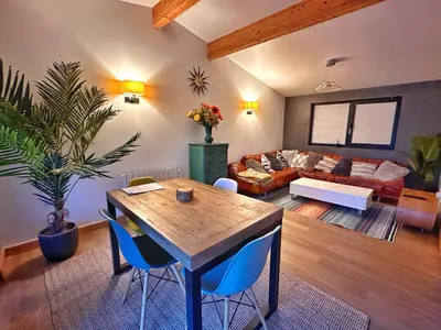 a living room with a table and a couch at Chy Mena. South facing lodge with hot tub & views. in St. Agnes