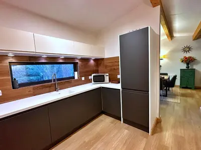 a kitchen with a sink and a refrigerator at Chy Mena. South facing lodge with hot tub & views. in St. Agnes