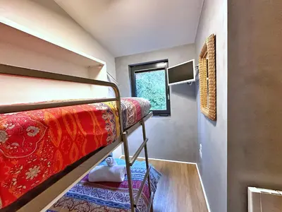 a room with two bunk beds and a window at Chy Cos. South facing lodge with balcony & views. in St. Agnes