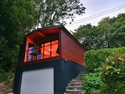 a small red brick house with a window and stairs at Chy Cos. South facing lodge with balcony & views. in St. Agnes
