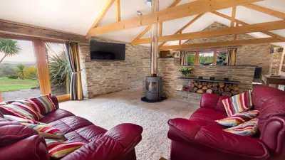 a living room with a couch and a fireplace at BADGERS HOLLOW in Fowey