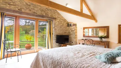 a bedroom with a bed and a large window at BADGERS HOLLOW in Fowey