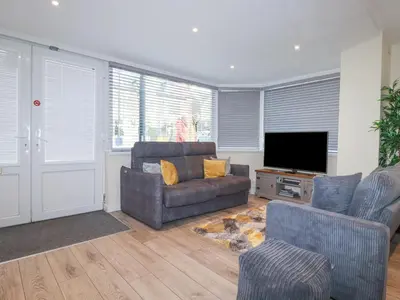 a living room with a couch and a television at Falcon House in Tintagel