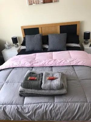 a bed with two towels and two pillows on it at All March 70 pounds per night with 3 nights minimum stay in St Austell