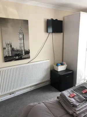 a bedroom with a bed and a picture of big ben at All March 70 pounds per night with 3 nights minimum stay in St Austell