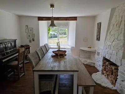 a living room with a table and a fireplace at The Farmhouse, Fowey in Fowey
