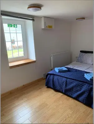 a bedroom with a bed and a window at Cornwall - Unique two storey barn in St Austell