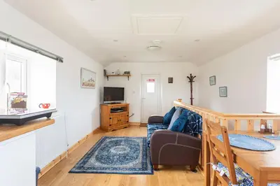 a living room with a couch and a table at Cornwall - Unique two storey barn in St Austell