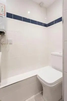 a white bathroom with a toilet and a sink at Cornwall - Unique two storey barn in St Austell