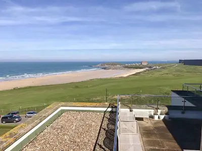 a view of the beach from the balcony of a house at 7 Ocean Gate in Newquay