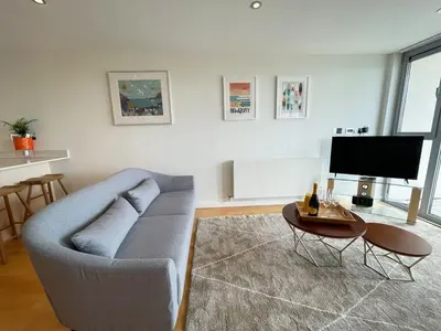 a living room with a couch and a table and a tv at 8 Zinc in Newquay
