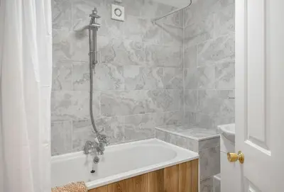a bathroom with a bath tub and a sink at Harbour Steps in Falmouth
