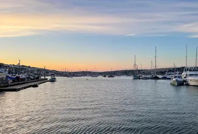 a group of boats docked in a harbor at sunset at Harbour Steps in Falmouth