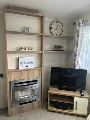 a living room with a flat screen tv and a entertainment center at Our Lodge at Newquay Bay NB35 in Newquay