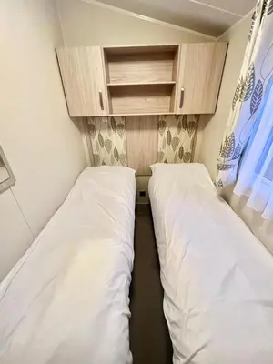 two beds in a small room with cabinets at Our Lodge at Newquay Bay NB35 in Newquay