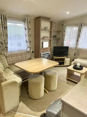a living room with a table and a tv at Our Lodge at Newquay Bay NB35 in Newquay
