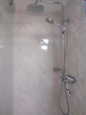a shower with a glass door in a bathroom at Sandy cottage, nr Eden & beaches in St Austell