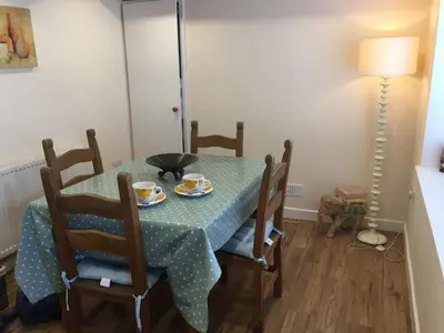 a dining room table with two cups and chairs at Sandy cottage, nr Eden & beaches in St Austell
