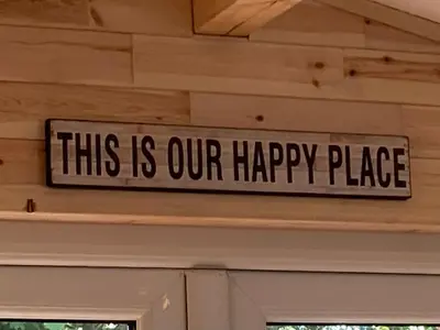 a sign that says this is our happy place on a wall at Laity's Lodge in Penzance