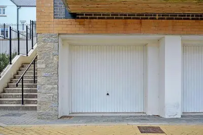 two garage doors on the side of a brick building at Stunning Apartment, balconies, private beach, coast path in Charlestown