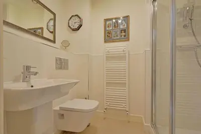 a bathroom with a sink and a toilet and a shower at Stunning Apartment, balconies, private beach, coast path in Charlestown