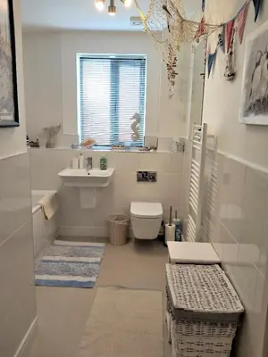 a white bathroom with a sink and a toilet at Stunning Apartment, balconies, private beach, coast path in Charlestown