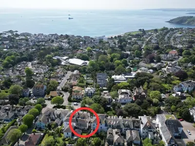 a red circle in a city with houses at Treetops - Characterful flat with parking, close to beach in Falmouth