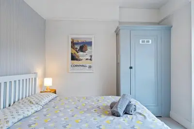 a bedroom with a bed with a stuffed animal on it at Pendennis - Bright Victorian flat, sea views & close to beach in Falmouth