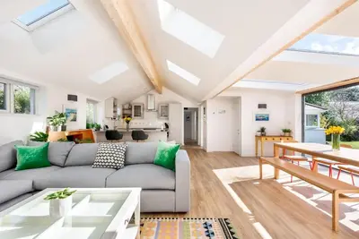 a living room with a couch and a table at Trevint - Modern beach house in Falmouth near beach, private garden and parking in Falmouth