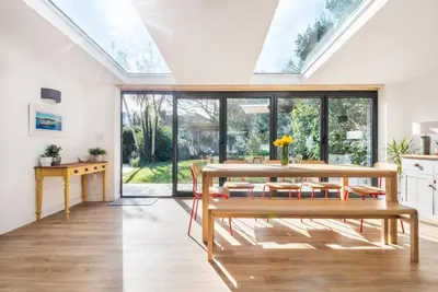 a kitchen and dining room with a skylight at Trevint - Modern beach house in Falmouth near beach, private garden and parking in Falmouth