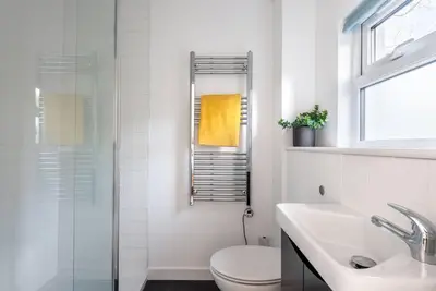 a bathroom with a toilet and a sink and a shower at Trevint - Modern beach house in Falmouth near beach, private garden and parking in Falmouth