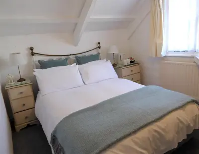 a bedroom with a large white bed and a window at Grey Mullet Guest House in St Ives