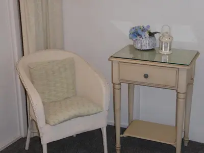 a table and a chair next to a side table at Grey Mullet Guest House in St Ives