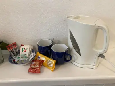 a toaster sitting on a counter next to two cups at Grey Mullet Guest House in St Ives