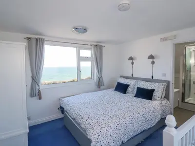 a bedroom with a bed with a view of the ocean at Sea View in Mevagissey