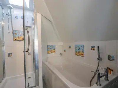 a white bathroom with a tub and a shower at Sea View in Mevagissey