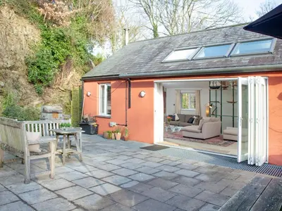 an extension to a house with a patio with a couch at The Studio At Granny's Well in Fowey
