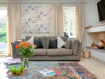 a living room with a couch and a table at The Studio At Granny's Well in Fowey