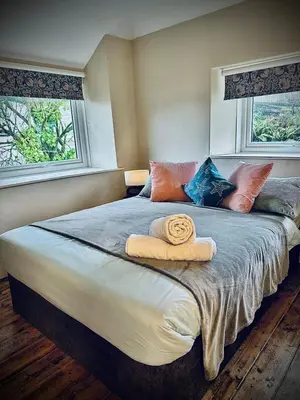 a bedroom with a large bed with two towels on it at Waterside Victorian house at Golant Fowey in Fowey