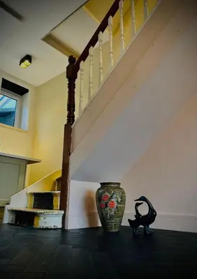 a vase sitting on a floor next to a staircase at Waterside Victorian house at Golant Fowey in Fowey