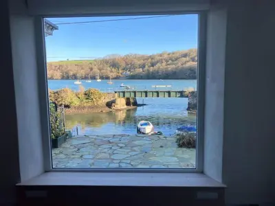 a window with a view of a body of water at Waterside Victorian house at Golant Fowey in Fowey