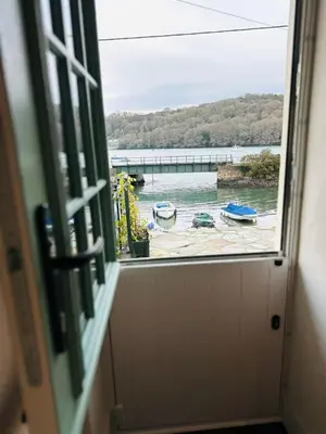a window with a view of a body of water at Waterside Victorian house at Golant Fowey in Fowey
