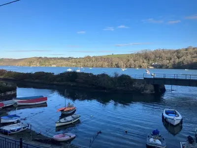 a group of boats in the water near a bridge at Waterside Victorian house at Golant Fowey in Fowey