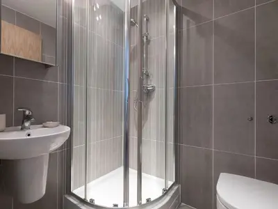 a shower with a glass door next to a sink at Atlantis in St Ives