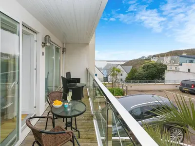 a balcony with a table and chairs and a car at Atlantis in St Ives