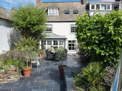 a garden in front of a house with plants at Trevan House, Port Isaac Bay Holidays in Port Isaac