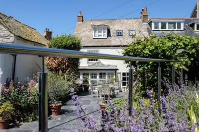 a garden with purple flowers in front of a house at Trevan House, Port Isaac Bay Holidays in Port Isaac