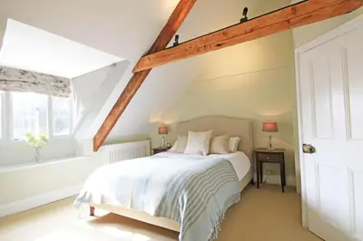 a bedroom with a white bed and a window at Trevan House, Port Isaac Bay Holidays in Port Isaac